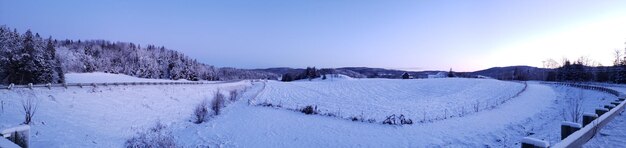 Panoramic view of snow covered landscape against sky