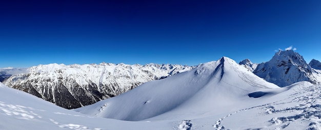 Vista panoramica delle cime delle montagne innevate nel cielo blu delle nuvole caucaso