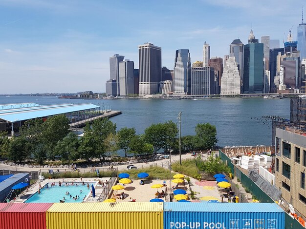 Panoramic view of swimming pool by buildings against sky