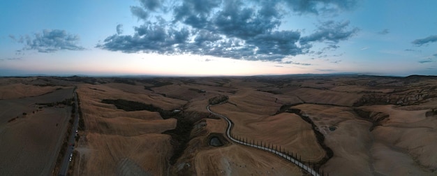 Panoramic view on the top a hill in Val d'Orcia. Landscape scenery at sunset of Tuscany in Italy