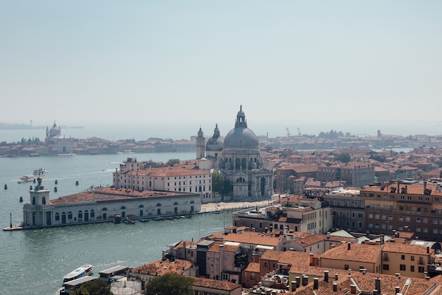 Панорамный вид на Венецию и базилику Санта-Мария-делла-Салюте (Святая Мария Здоровья) с Кампанилы Сан-Марко (Campanile di San Marco). Пейзаж летнего дня и солнечного голубого неба