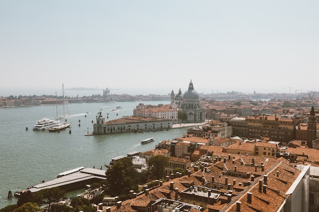 Panoramic view of Venice city and away Basilica di Santa Maria della Salute (Saint Mary of Healt) from St Mark's Campanile (Campanile di San Marco). Landscape of summer day and sunny blue sky