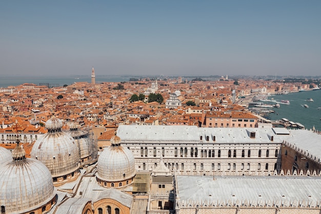 サンマルコ鐘楼からの歴史的建造物と海岸のあるヴェネツィア市のパノラマビュー。夏の日の風景と晴れた青空