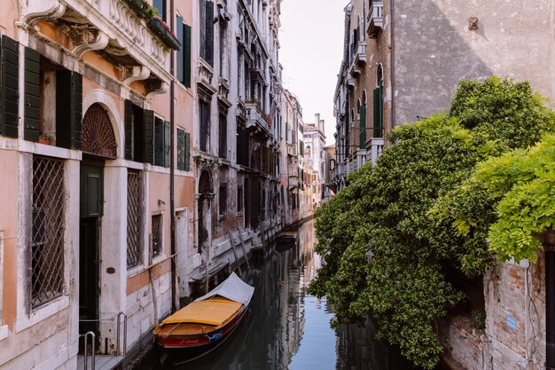 Panoramic view of Venice narrow canal with historical buildings and boat from bridge. Landscape of summer sunny day