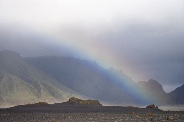 Panoramic view with Volcanic landscape during rain with rainbow over the mountain. Iceland, Laugavegur hiking trek.