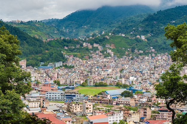 Panoramisch bovenaanzicht van de stad Katmandu, de hoofdstad van Nepal. Bomen op de voorgrond, stockfoto.