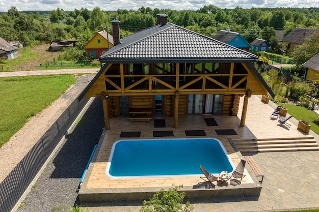 Panoramisch luchtfoto op houten eco-huis of hoeve met zwembad in groen dorp