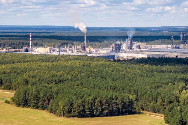 Panoramisch luchtfoto van de stad met een enorme fabriek met rokende schoorstenen op de achtergrond