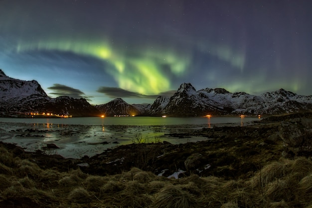 panoramisch uitzicht op aurora borealis over berg en meer