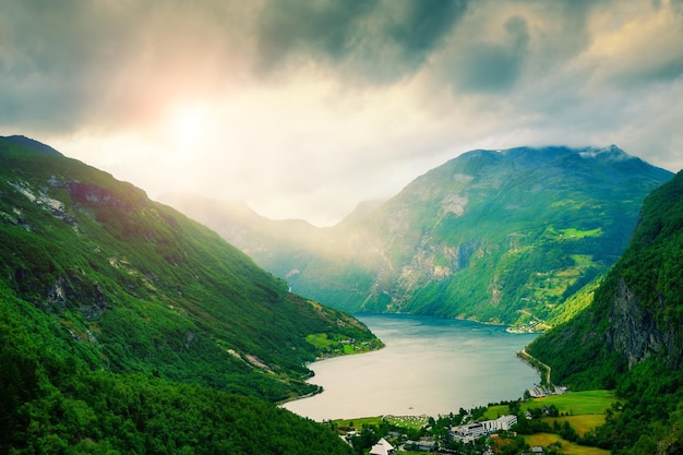 Panoramisch uitzicht op de Geiranger-fjord in Noorwegen. Stormachtige wolken boven de groene bergen. Mooie zomerse landschap. Beroemde reisbestemming