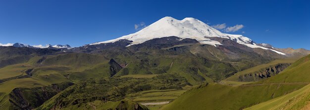 Panoramisch uitzicht op de noordelijke helling van de berg Elbrus van de bergen van de Kaukasus in Rusland. Met sneeuw bedekte toppen van de stratovulkaan.