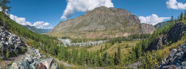 Panoramisch uitzicht op een bergdal met een rivier, bos, blauwe lucht en heuvelpad