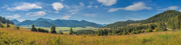 Foto panoramisch uitzicht op een bergdal, weide op de voorgrond, blauwe lucht met wolken