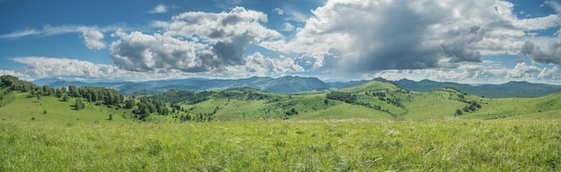 Panoramisch uitzicht op een zomerdag in de bergen, groene weiden, berghellingen en heuvels