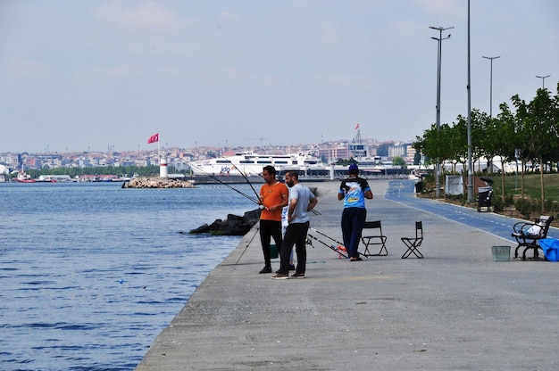 Panoramisch zicht op de dijk van de Basfor Strait, Istanbul. Vissers aan de kade. 10 juli 2021 Istanbul, Turkije.