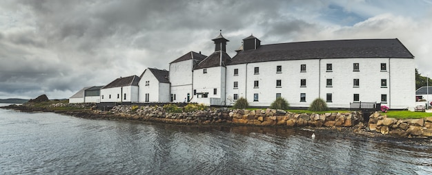 Panoramisch zicht op de gebouwen van de Laphroaig-distilleerderij islay Island, Schotland, grijze bewolkte hemel vóór de