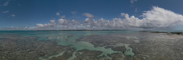 Panoramisch zicht op toeristen en kleine boten in natuurlijke zwembaden in Porto de Galinhas