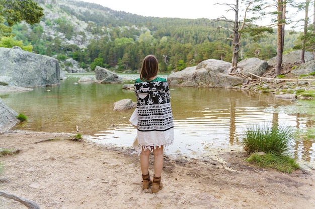 Foto panoramisch zicht van onherkenbare vrouw die voor de zwarte lagune in soria staat. horizontale weergave van reislustige vrouw wandelen in de natuur. mensen en reisbestemmingen in spanje.