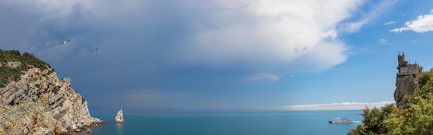 panoramische foto van dramatische lucht boven de rotsachtige kust naast het zwaluwnestkasteel