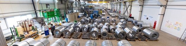 Foto panoramische foto van productielijn van metalen tegel voor dak. staalvormmachine in de werkplaats van de metaalbewerkingsfabriek. profileermachine voor metalen platen. achtergrond van plant