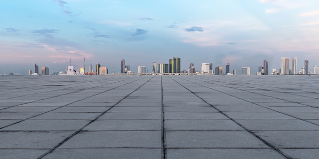 Panoramische lege concrete vloer en horizon met gebouwen