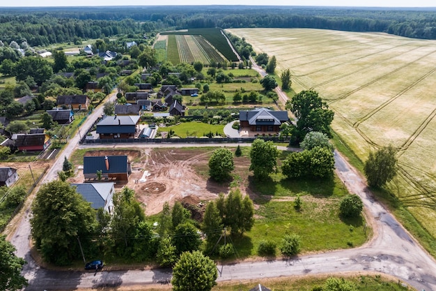 Panoramische luchtbeeld van eco-dorp met houten huizen, grindwegen, tuinen en boomgaarden