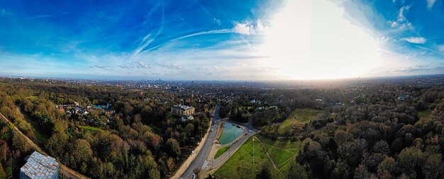 Foto panoramische luchtbeeld van een weelderig groen landschap met een weg onder een heldere blauwe hemel met dunne wolken