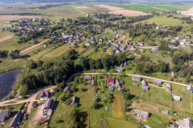 Panoramische luchtfoto van ecodorp met houten huizen, grindwegtuinen en boomgaarden