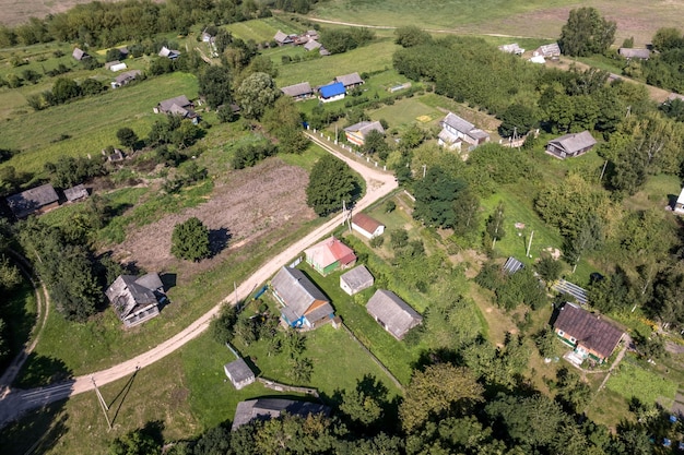 Panoramische luchtfoto van ecodorp met houten huizen, grindwegtuinen en boomgaarden