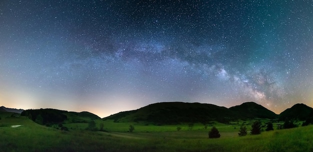 Panoramische nachtelijke hemel boven de hooglanden van Montelago, Marche, Italië De Melkwegboog en sterren in een uniek heuvellandschap