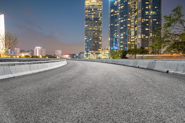 Panoramische skyline en lege asfaltweg met moderne gebouwen