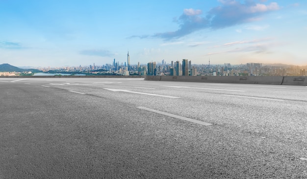 Panoramische skyline en lege asfaltweg met moderne gebouwen