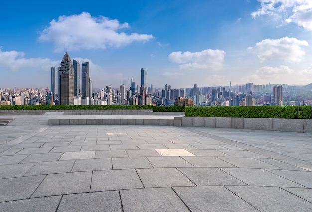 Panoramische skyline en lege vierkante vloertegels met moderne gebouwen