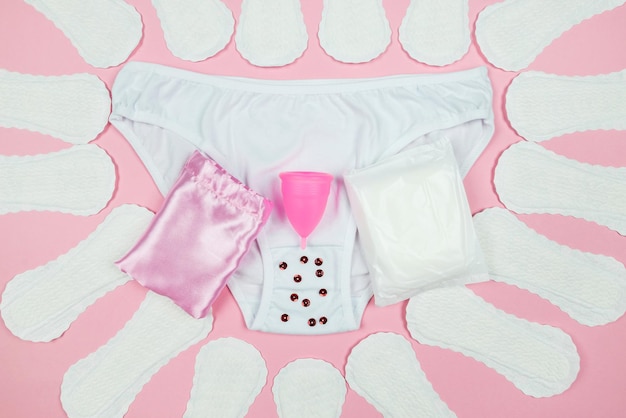 Panties pads menstrual cup on a pink background The concept of women's periods