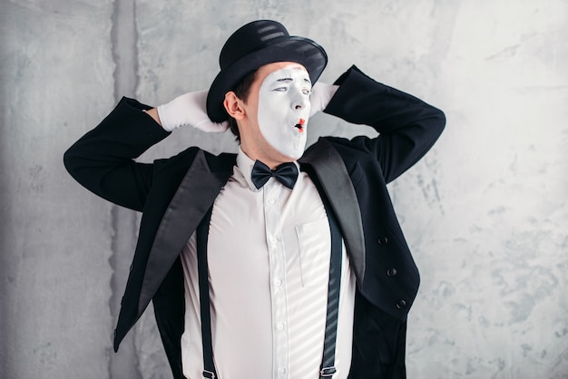 Pantomimekunstenaar met make-upmasker. mime in pak, handschoenen en hoed.