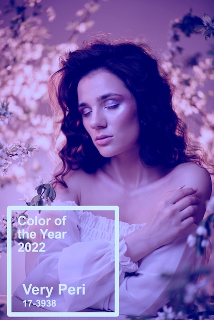Фото Цвет pantone 2022 года - very peri. фантастический снимок девушки в цветах с неоновым разноцветным светом и фантасмагорией.