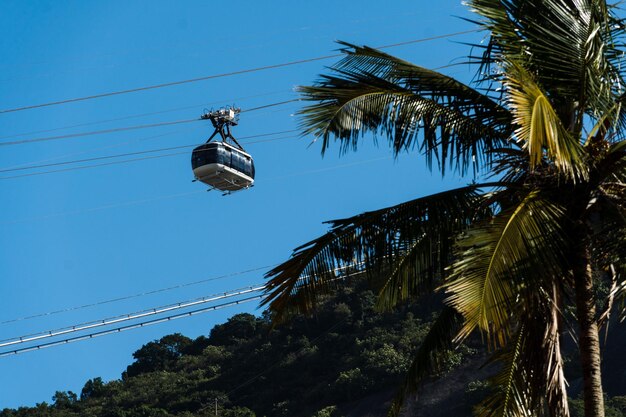 Pao de Acucar cable car passing with the hill in the background Neighborhood of Urca in Rio de Janeiro Brazil Sunny day at dawn Blue sky