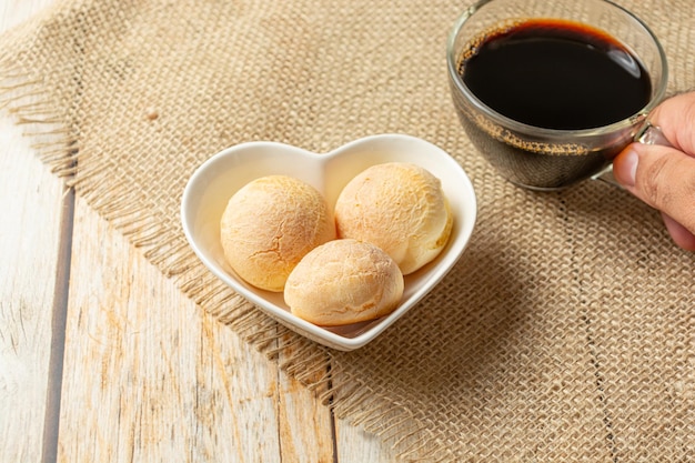 pao de queijo in a heart shaped bowl with coffee