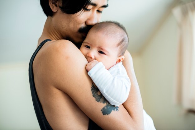 Papa die zijn baby-familie-emotie thuis draagt