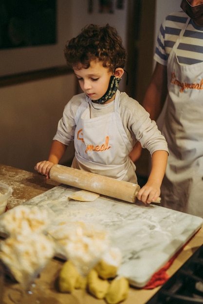 Papa en kinderen koken pasta tijdens een masterclass gastronomie