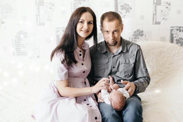 Papa en mama kijken voorzichtig naar hun pasgeboren baby