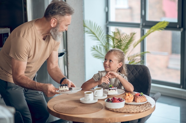 Papa en zijn dochter samen aan het ontbijten thuis