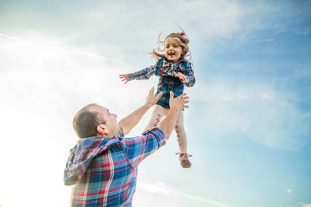 Papa gooit het meisje in de lucht