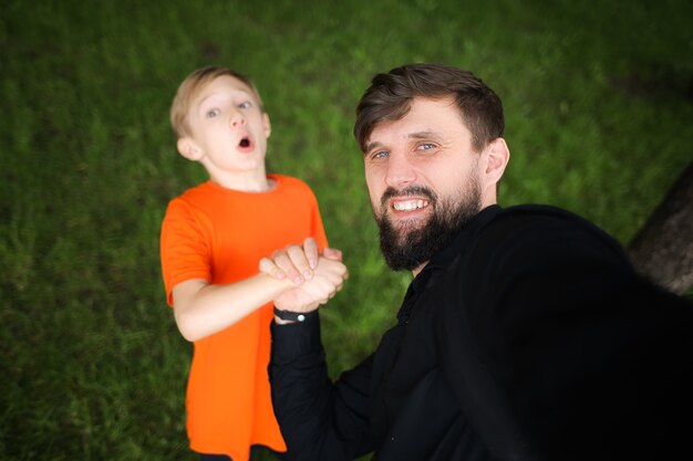 Papa maakt een selfie terwijl hij de hand van het kind vasthoudt