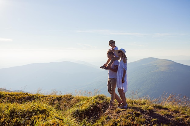 Papa, mama en hun zoon genieten van het landschap in de bergen