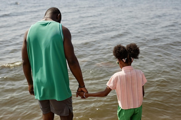 Papa met dochter die zich op het strand bevindt