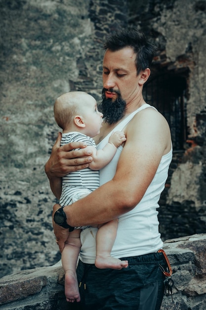 Papa met een baby in zijn armen tegen de achtergrond van zeepbellen en een oud kasteel