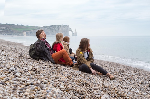 Papa met mama en twee dochters zittend op het strand van Etretat