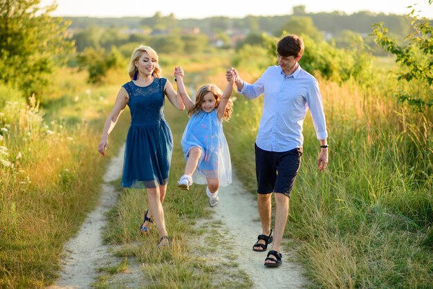 Papa, moeder en dochter hebben samen plezier in de natuur.