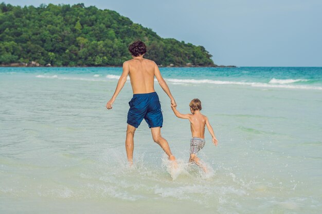 Papa speelt met zijn zoon in de zee